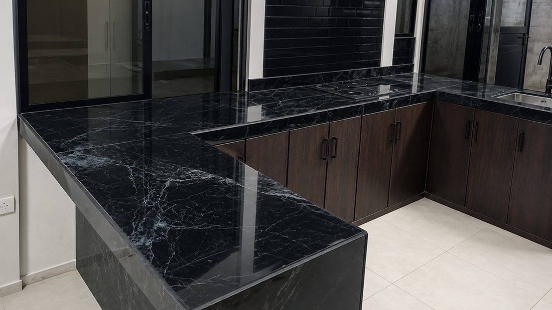Cocina remodelada por UnoTico™ con encimeras de mármol negro y gabinetes de madera oscura